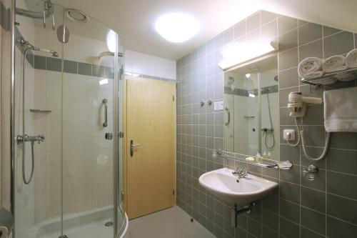 a bathroom with a sink and a shower at Hotel DAP in Prague