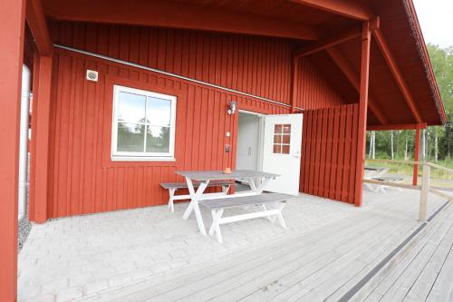 a red building with a picnic table on a patio at Kosta Lodge in Kosta