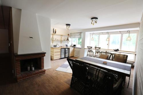a kitchen and dining room with a table and a fireplace at Kosta Lodge in Kosta