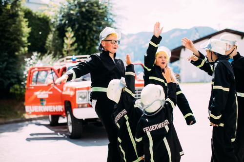 a group of people in firefighting gear in front of a fire truck at Pitzis Kinderhotel - Family Only in Arzl im Pitztal