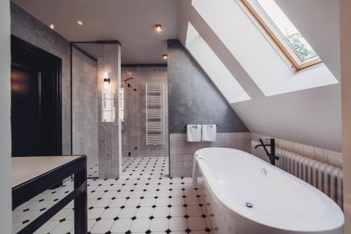 Apartamenty Jan Olbracht في تورون: حمام مع حوض استحمام ونور