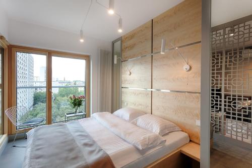 a bedroom with a large bed and a window at Mennica Residence in Warsaw