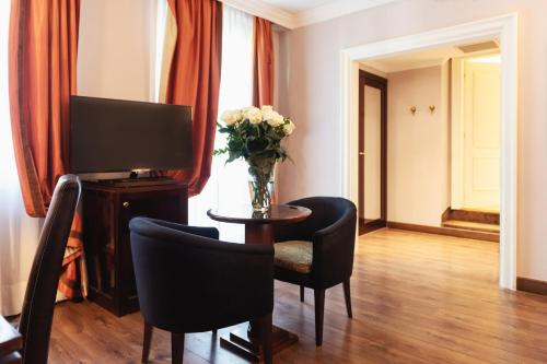 a living room with a television and a table with chairs at Allegroitalia San Gallo Firenze in Florence