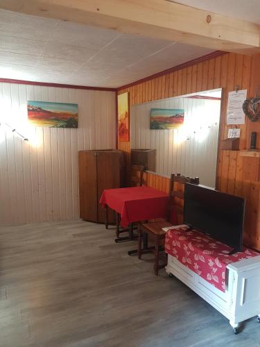 a room with a table and chairs and a red table at Le Nid Du Caveau in Ferrette