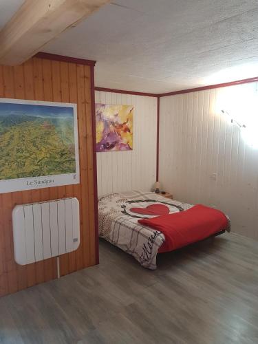 a bedroom with a bed and a painting on the wall at Le Nid Du Caveau in Ferrette