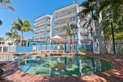 un edificio con piscina frente a un edificio en White Crest Apartments en Hervey Bay