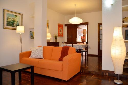 a living room with an orange couch and a dining room at Holiday in Rome in Rome