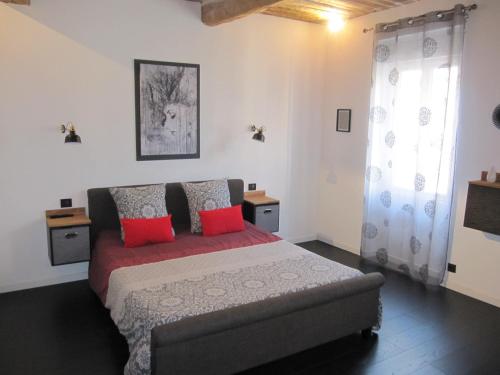 a bedroom with a bed with red pillows and a couch at La Terracotta in Vidauban