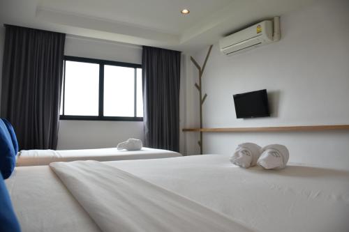 a hotel room with two beds with towels on them at B Boutique Residence in Suratthani