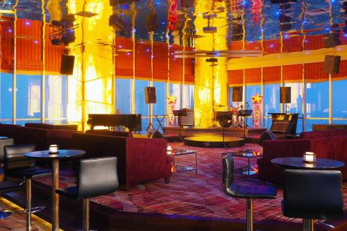 a room with tables and chairs and a stage at Cambridge Hotel Medan in Medan
