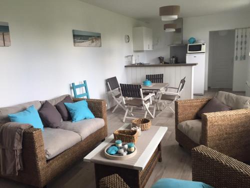 a living room with two couches and a table at La Longère à la Mer 6 pers 3 chambres grand jardin clôt a Fort-Mahon-Plage in Fort-Mahon-Plage