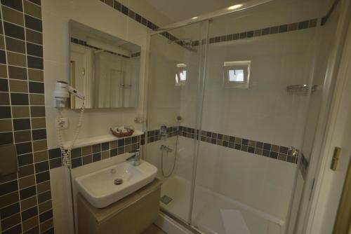 a bathroom with a shower and a sink and a mirror at Sarnic Premier Hotel in Istanbul