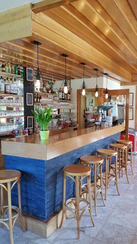een bar met een rij krukken in een restaurant bij Hôtel Plein Soleil in Vacheresse