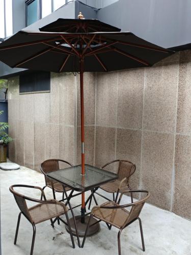 a glass table with chairs and an umbrella at Hotel The May in Busan