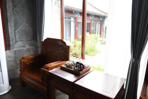 Habitación con escritorio y ventana grande. en Chengde Kai Ren Hua Fu Jiu Dian (Bi Shu Shan Zhuang Dian) en Chengde