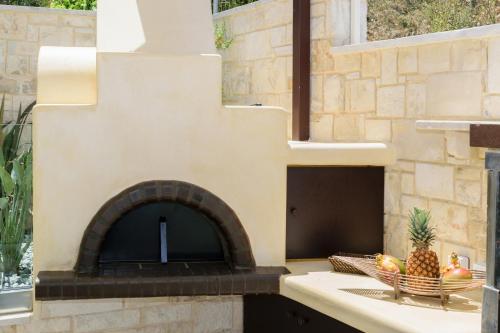 a stone oven with a bowl of fruit on a counter at Villa Thalia in Stalos