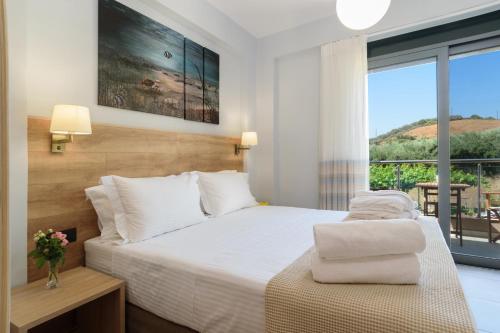 a bedroom with a bed and a large window at Villa Thalia in Stalos