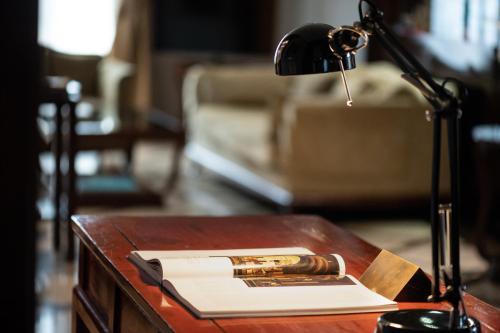a desk with a lamp and a book on a table at Allegroitalia San Gallo Firenze in Florence