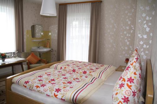 ein Schlafzimmer mit einem Bett mit einer Blumendecke darauf in der Unterkunft Weinfelderhof in Kröv