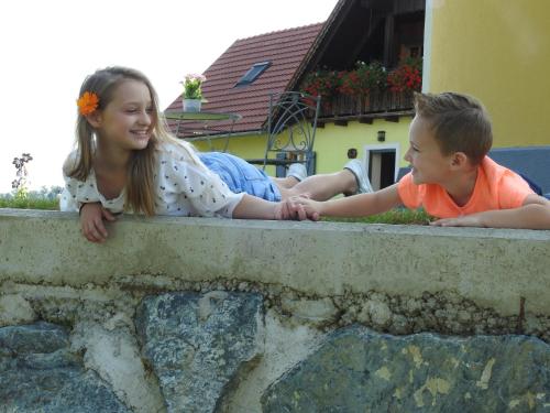 a boy and a girl laying on a wall at Ferienwohnung Kleissner in Großklein