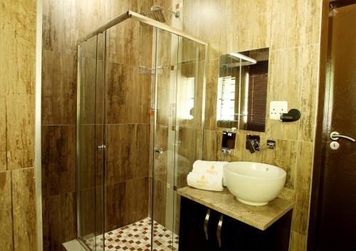 a bathroom with a glass shower and a sink at Rekky Signature Guesthouse in Johannesburg