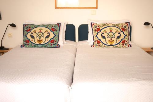 
two beds with pillows and pillows in a room at Τhe White Houses in Makry Gialos
