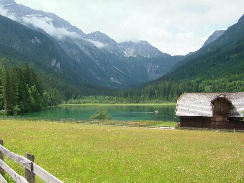 an old barn in a field next to a lake at Haus Katharina in Wagrain