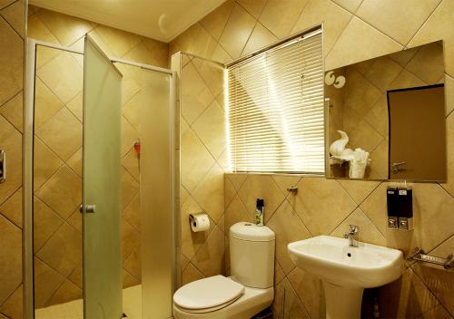 a bathroom with a toilet and a sink at Rekky Signature Guesthouse in Johannesburg