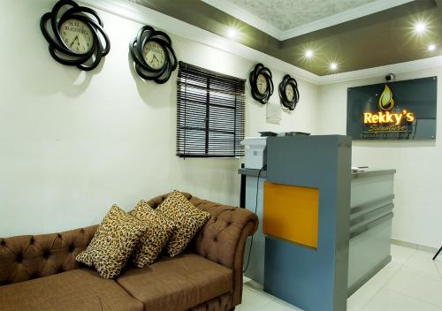 a living room with a couch and clocks on the wall at Rekky Signature Guesthouse in Johannesburg