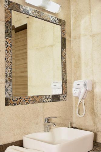 a bathroom with a sink and a mirror at Anna Pousi Studios & Apartment in Ormos Panagias