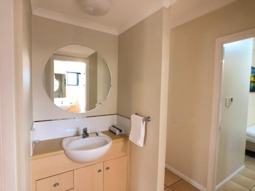 a bathroom with a sink and a mirror at City Plaza Apartments in Cairns