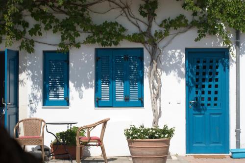 
a blue door leading to a room with a blue bench at Τhe White Houses in Makry Gialos
