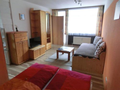 ein Wohnzimmer mit einem Bett und einer Kommode in der Unterkunft Appartement Inge in Kaprun