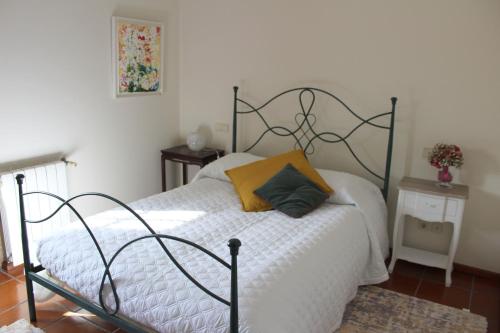 a bedroom with a bed with a yellow pillow on it at Quinta do Sardão in Boticas