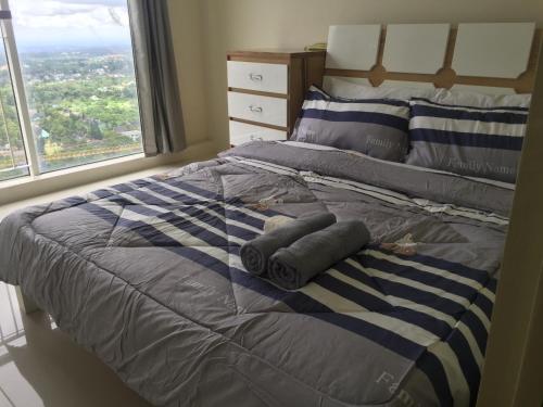 a bedroom with a bed with two pillows and a window at Wind Residences by SMCo in Tagaytay