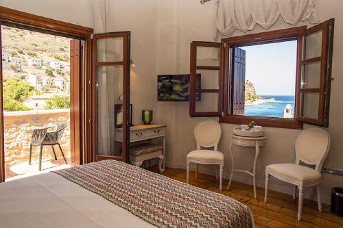 a bedroom with a bed and a view of the ocean at Limeni Inn Boutique Hotel Adults only 12plus in Limeni