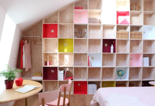 a bedroom with a wall of bookshelves with a bed and a table at Le Petit Rivage in La Charité-sur-Loire