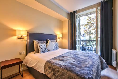 a bedroom with a large bed and a window at 60-LUXURY PARISIAN HOME SEBASTOPOL (2DG) in Paris