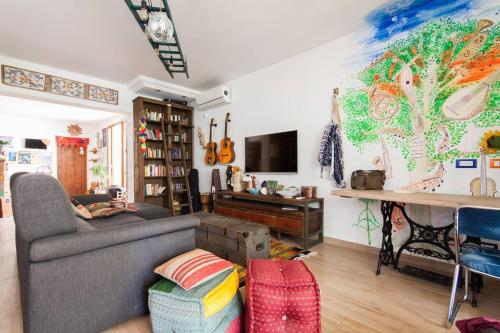 a living room with a couch and a painting on the wall at Timbuktu Hostel in San Vito lo Capo