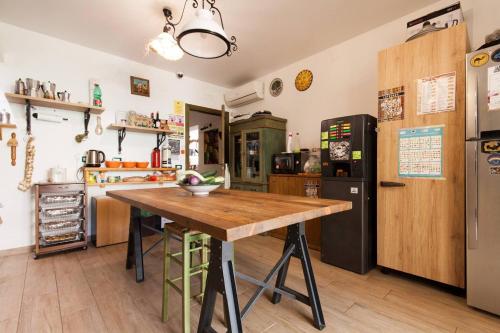 a kitchen with a table and a refrigerator at Timbuktu Hostel in San Vito lo Capo