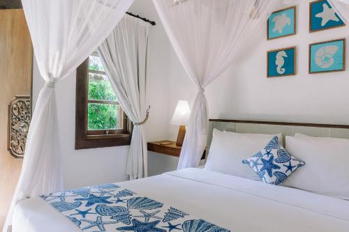 a bedroom with a bed and a window at Alam Candi Resort in Candidasa