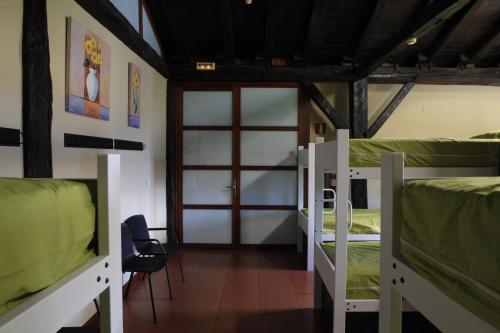 Aduna的住宿－Albergue Uztartza，带三张双层床和一扇门的房间