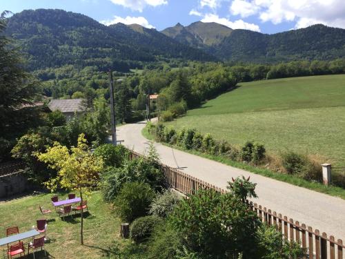 einen Weg mit Bänken und Bergen im Hintergrund in der Unterkunft Auberge du Grand Champ in Lalley