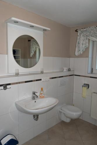 a white bathroom with a sink and a toilet at Ferienwohnung Holzinger in Hauzenberg