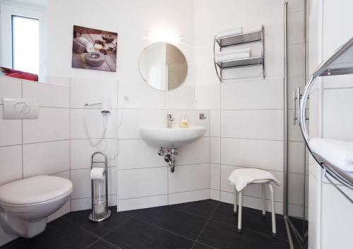 een witte badkamer met een toilet en een wastafel bij Ferienhäuser am Hainich in Hörselberg-Hainich