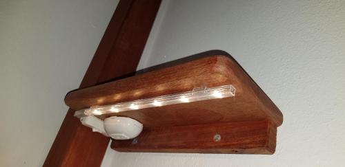 a lightswitch on a wall with a wooden door at Surf House Hostel in Santa Maria