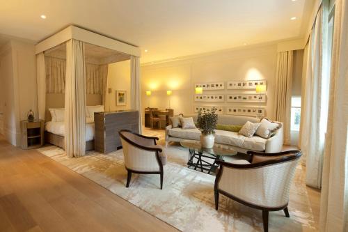 a living room with a couch and a table and chairs at Coworth Park - Dorchester Collection in Ascot