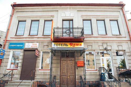 a building with a sign on the front of it at Rawa in Rava-Rusʼka