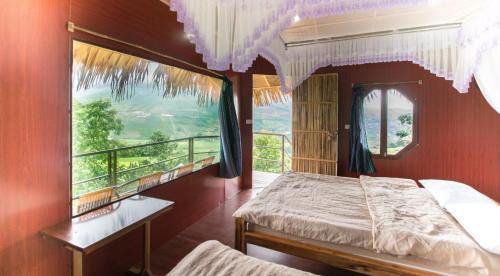 a bedroom with a bed and a large window at Eco Hills Homestay in Sa Pa