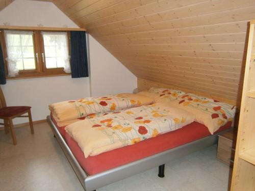 Bett in einem Zimmer mit Holzdecke in der Unterkunft Ferienwohnung Brülisauer in Brülisau